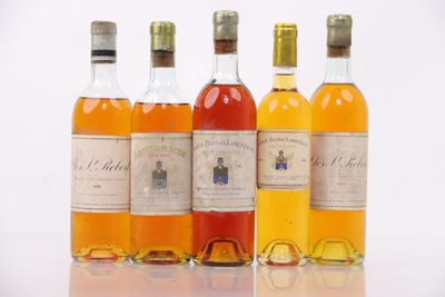 four bottles of different types of alcohol are lined up on a white surface