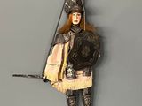 a figurine of a man dressed in armor hanging on a wall
