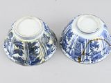 two blue and white vases sitting on a table