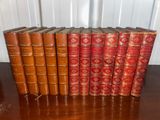 several old books are lined up on a wooden table