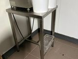 two buckets sitting on a metal table in a kitchen