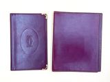 deux carnets en cuir violet posés l'un à côté de l'autre sur une surface blanche