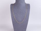 un collier à chaîne en or sur un présentoir à mannequin
