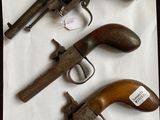trois vieux revolvers sont posés sur une feuille de papier, sur une table