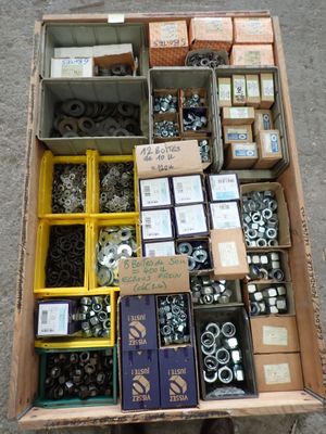 a box full of assorted bolts and nuts on the ground