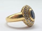 an image of a gold ring with a blue stone surrounded by white diamonds