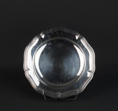 a silver plate on a stand against a black background