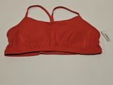 un gros plan d'un haut de soutien-gorge rouge posé sur une surface blanche