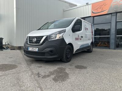 La camionnette est garée devant un immeuble sur lequel est accrochée une pancarte.