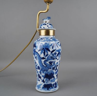 une image représentant un vase bleu et blanc muni d'une anse dorée