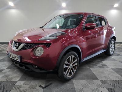 the red nissan juke suv is parked in a large room