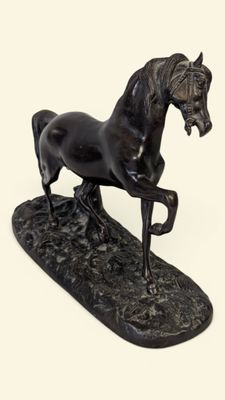statue d'un cheval noir sur un socle noir, sur fond blanc