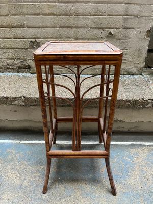 a small wooden table with a glass top on a sidewalk
