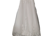 une robe de mariée suspendue à un cintre accroché au mur