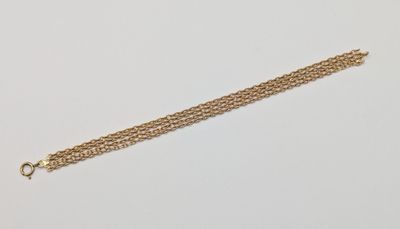 a close up of a gold chain bracelet on a white surface