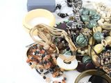 a pile of assorted jewelry on a white table
