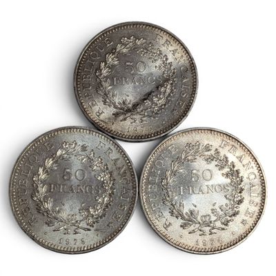 three silver coins sitting on top of each other on a white surface