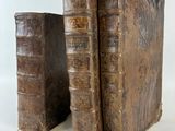 deux vieux livres posés l'un à côté de l'autre sur une surface blanche