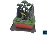 a miniature bonsai tree in a red pot on a stand