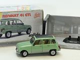 une petite voiture verte en plastique devant une boîte