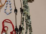a lot of necklaces that are laying on a table