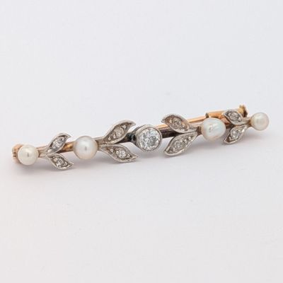un gros plan sur une broche ornée de perles et de diamants