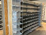 many empty shelves in a store that are being cleaned