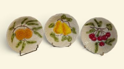 three small plates with fruit designs on them on a white surface