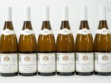 six bouteilles de vin sont alignées sur une table