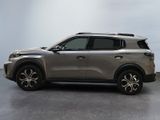 the silver suv is parked in a room with a gray wall