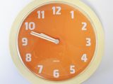 une horloge jaune avec des chiffres blancs sur fond blanc
