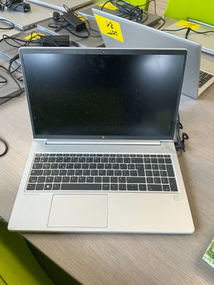 a laptop computer sitting on a desk with a lot of wires