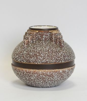 a brown and white vase sitting on a white surface