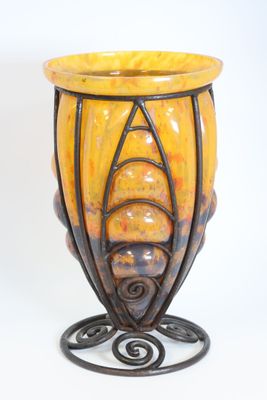 a yellow vase that is sitting on top of a stand