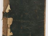 an old book with torn pages sitting on top of a white surface