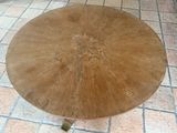 a round table with a wooden top on a tiled floor