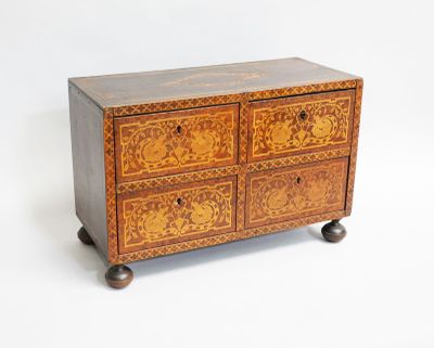 a small wooden chest of drawers on wheels on a white background