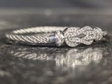 a silver ring with a knot on it on a table