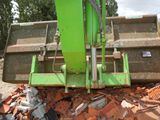 a green machine that is sitting on top of a pile of bricks
