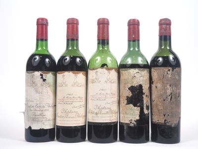 quatre bouteilles de vin sont alignées sur une surface blanche