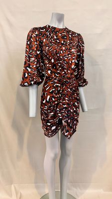 un mannequin vêtu d'une robe marron et blanche, sur un socle blanc