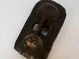 un objet noir posé sur une surface blanche et percé d'un trou