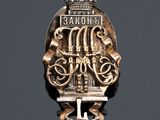 a close up of a metal badge with a crown on it