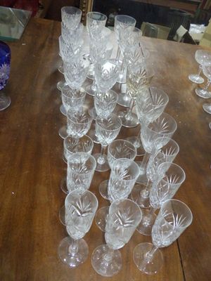 plusieurs verres posés sur une table en bois, avec un vase bleu en arrière-plan