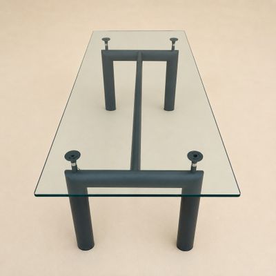 une table en verre avec deux pieds noirs et un plateau en verre