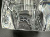 a glass vase with a label on it sitting on a table