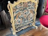 a red chair sitting in front of a fireplace with a tapestry on it