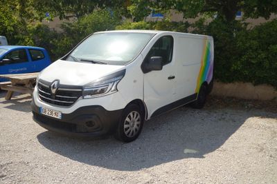 une camionnette blanche garée sur un parking à côté d'une voiture bleue