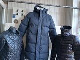 trois manteaux exposés dans la vitrine d'un magasin