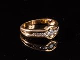 une image représentant une bague en or sertie de diamants sur un fond noir